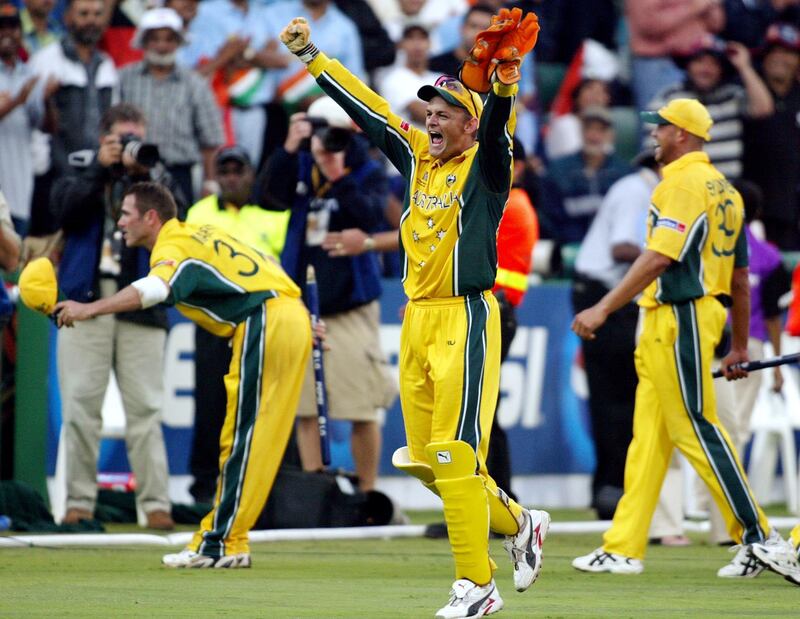Australian wicketkeeper Adam Gilchrist (C) celebrates as Damien Martyn (L) bows to the crowd and Andrew Symonds (R) looks on after Australia won the final of the ICC Cricket World Cup played at the Wanderers Stadium in Johannesburg 23 March 2003.  Batting first, Australia scored 359-2 from their 50 overs, their highest ever one-day total and then dismissed India for 234 to win by 125 runs.  AFP PHOTO/William WEST (Photo by WILLIAM WEST / AFP)
