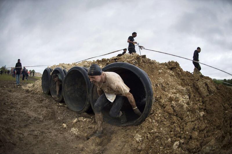 Runners take part in 'The Mud Day challenge', a 13-kilometre obstacles course, on in Beynes near Paris, on Saturday. Martin Bureau / AFP