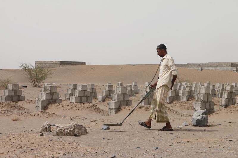 A member of a Yemeni demining unit with a metal detector searches for Houthi landmines on the outskirts of  Hodeidah.  EPA