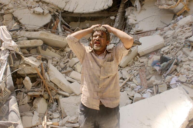 A man holds his head in his hands as he reacts in front of a rubble following a reported bomb attack by government forces in the northern city of Aleppo. Tamer Al-Halabi / AFP