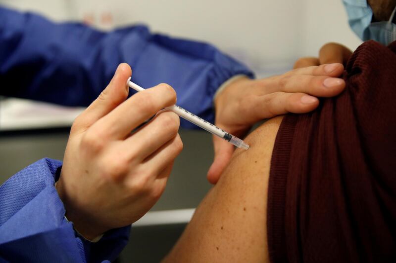 FILE PHOTO: A medical worker administers a dose of the "Comirnaty" Pfizer-BioNTech COVID-19 vaccine in a vaccination center in Paris as part of the coronavirus disease (COVID-19) vaccination campaign in France, May 12, 2021. REUTERS/Gonzalo Fuentes/File Photo