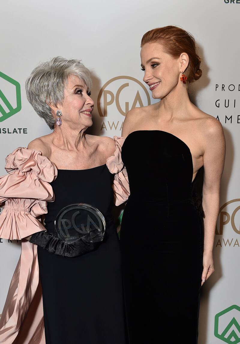 Rita Moreno and Jessica Chastain, wearing a black column 
Miu Miu dress, appear backstage at the 33rd Annual Producers Guild Awards on March 19, 2022 in Los Angeles. AP Images
