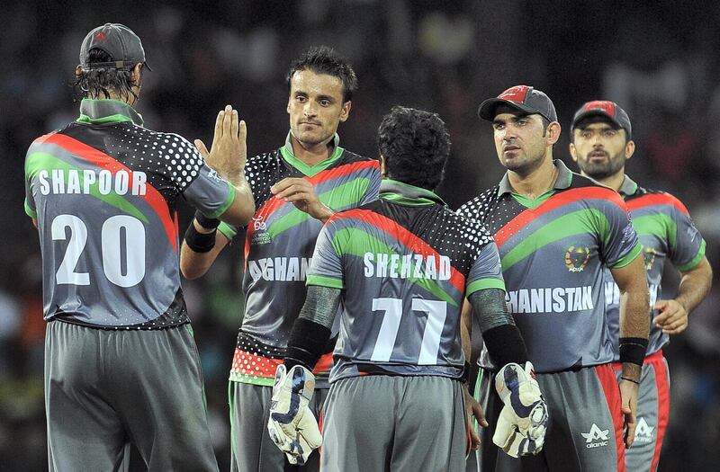 Afghan cricketer Izatullah Dawlatzai (2L) celebrates with teammates after he dismissed unseen England batsman Jos Buttler during the ICC Twenty20 Cricket World Cup match between England and Afghanistan at the R. Premadasa Stadium in Colombo on September 21, 2012. AFP PHOTO/ LAKRUWAN WANNIARACHCHI (Photo by LAKRUWAN WANNIARACHCHI / AFP)