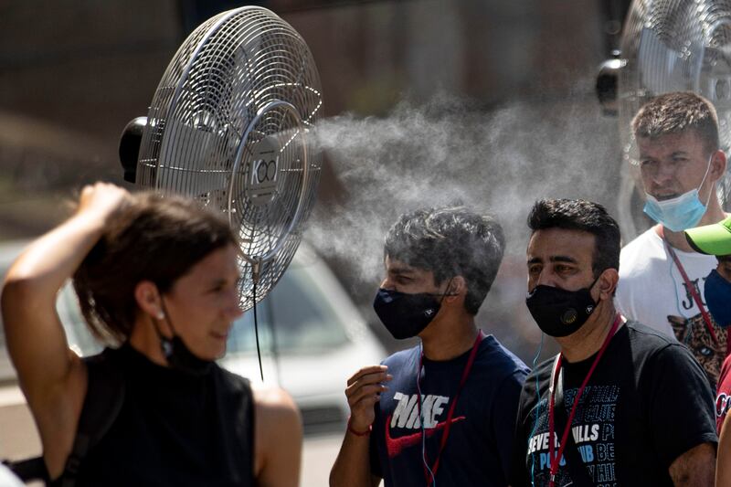 Tourists are sprayed with water by a fan in Rome. EPA