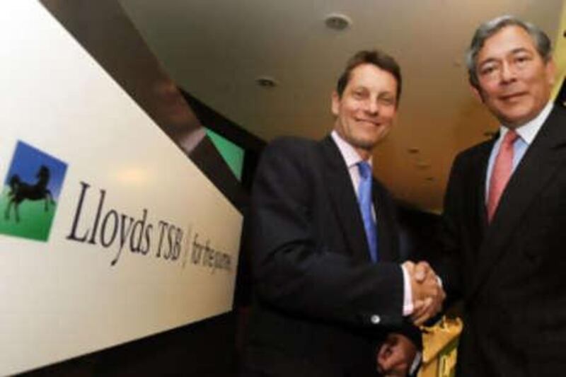 HBOS's chief executive Andy Hornby (L) shakes hands Lloyds's chief executive Eric Daniels.