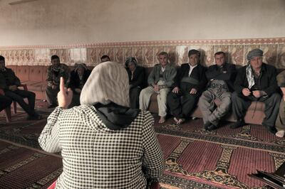 <p>Mrs Kurdistan Rasul talks to the men of Gomasheen in the village mosque.&nbsp;Florian Neuhof&nbsp;for The National</p>

