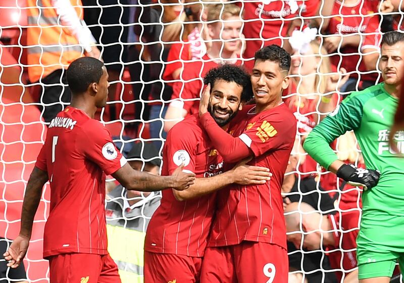 Liverpool's Egyptian striker Mohamed Salah celebrates with Roberto Firmino after scoring the team's third goal against Newcastle. EPA