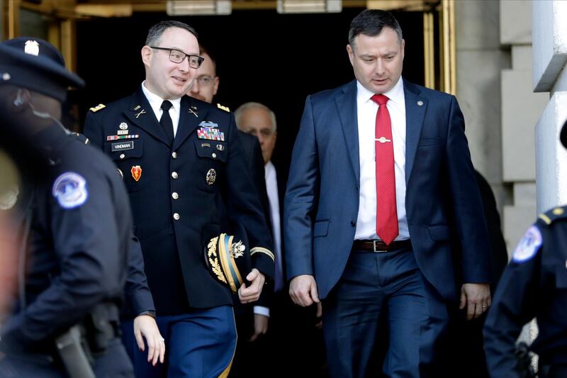FILE - In this Nov. 19, 2019, file photo then National Security Council aide Lt. Col. Alexander Vindman, left, walks with his twin brother, Army Lt. Col. Yevgeny Vindman, after testifying before the House Intelligence Committee on Capitol Hill in Washington, during a public impeachment hearing of President Donald Trump's efforts to tie U.S. aid for Ukraine to investigations of his political opponents. The Army confirms that both Lt. Cols. Vindman have been reassigned to the Department of the Army,(AP Photo/Julio Cortez, File)