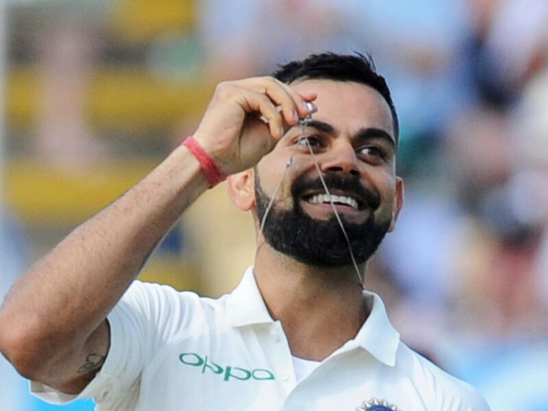 Indian cricket captain Virat Kohli holds up his wedding ring as he celebrates scoring a century during the second day of the first test cricket match between England and India at Edgbaston in Birmingham, England, Thursday, Aug. 2, 2018. (AP Photo/Rui Vieira)