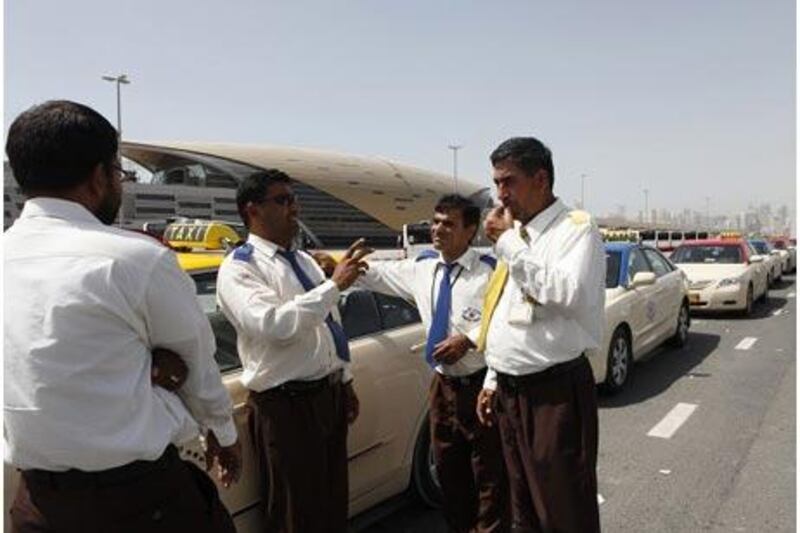 Taxi drivers, from left, Sham K, Noor Khan, Salim Khan and Naziz Khan wait for passengers near Ibn Battuta Metro Station.