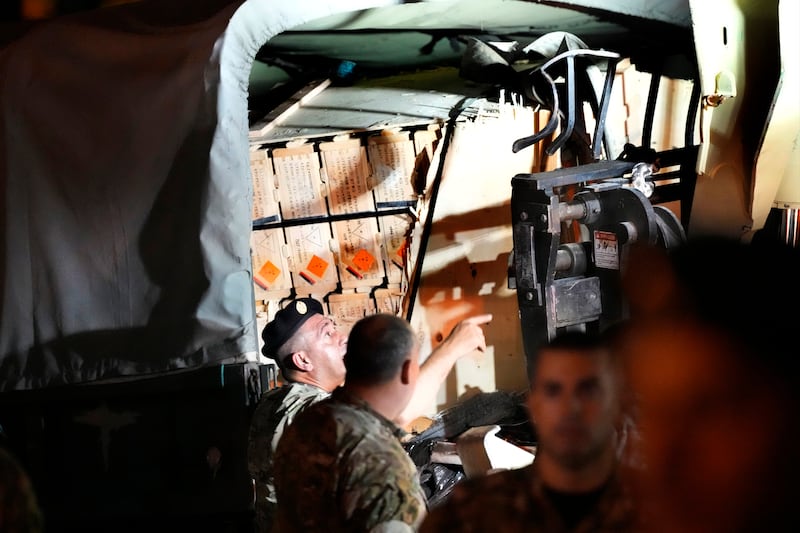 Lebanese soldiers load boxes on their military vehicle after they remove them from the lorry. AP