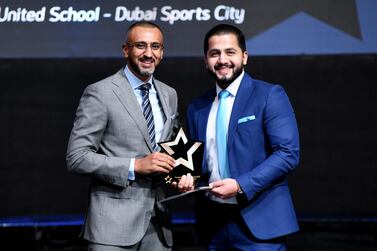 Mohammad Abusenenh receives his prize from Dino Varkey, chief executive of Gems Education. Courtesy Gems Education