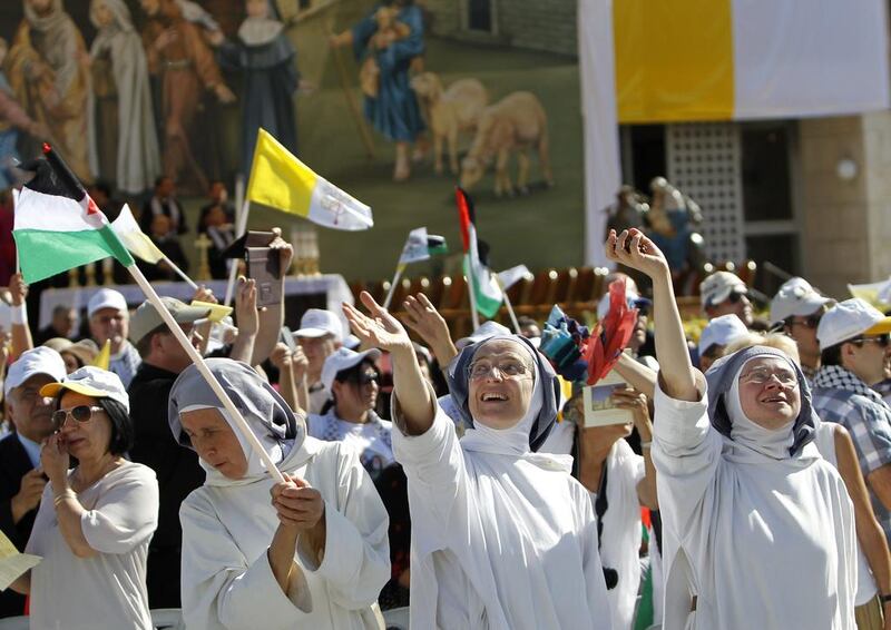 Nuns wave as they attend a mass led by Pope Francis at Manger Square outside the Church of the Nativity on May 25, 2014 in the West Bank town of Bethlehem. Abbas Momani/AFP Photo