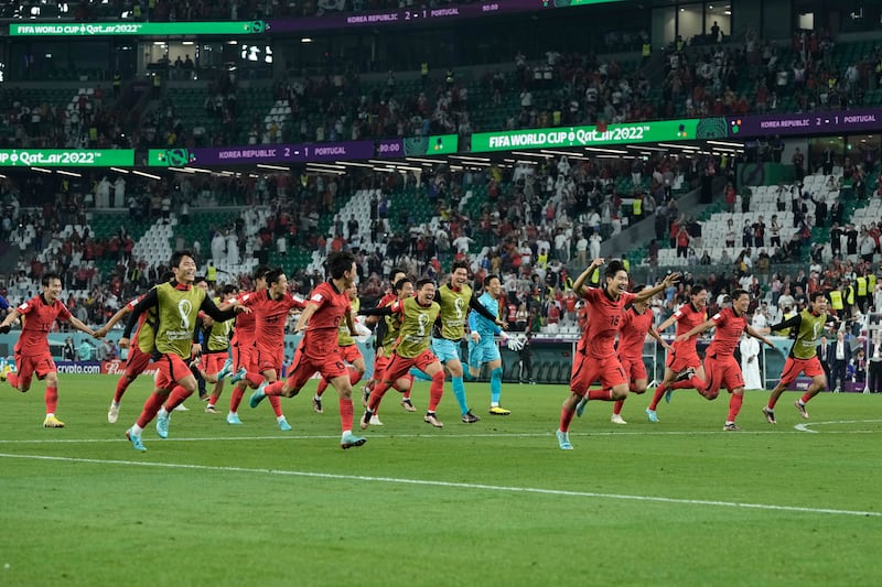 South Korea's players celebrate after finding out they had qualified for the last-16 ahead of Uruguay. AP