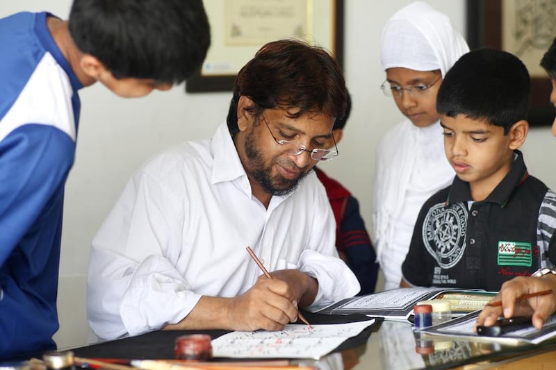 Muqtar Ahmed teaches the art of Islamic calligraphy to his students. Subhash Sharma for The National