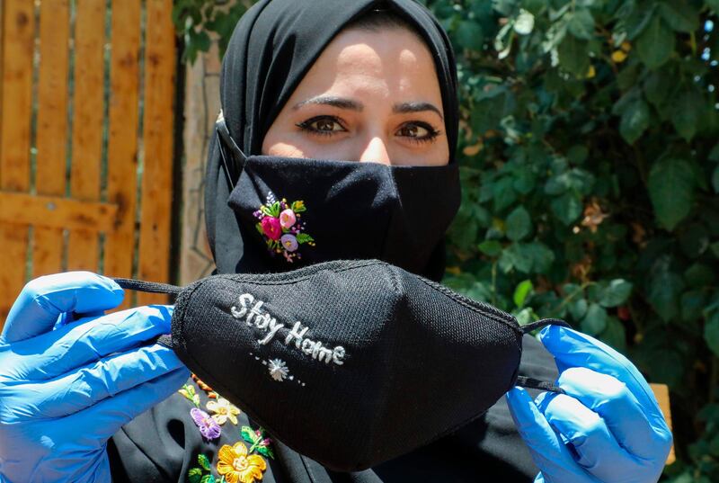 Palestinian Waad Manasra displays her hand-embroidered protective masks, sold also online, at her home in the village of Bani Naim, east of the West Bank city of Hebron, amid the pandemic. AFP