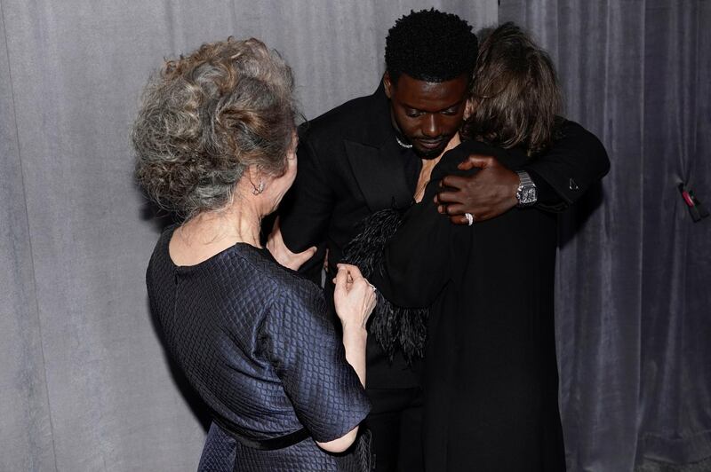 Youn Yuh-jung looks on as Daniel Kaluuya hugs Frances McDormand outside the press room at the Academy Awards in Los Angeles, California. Reuters