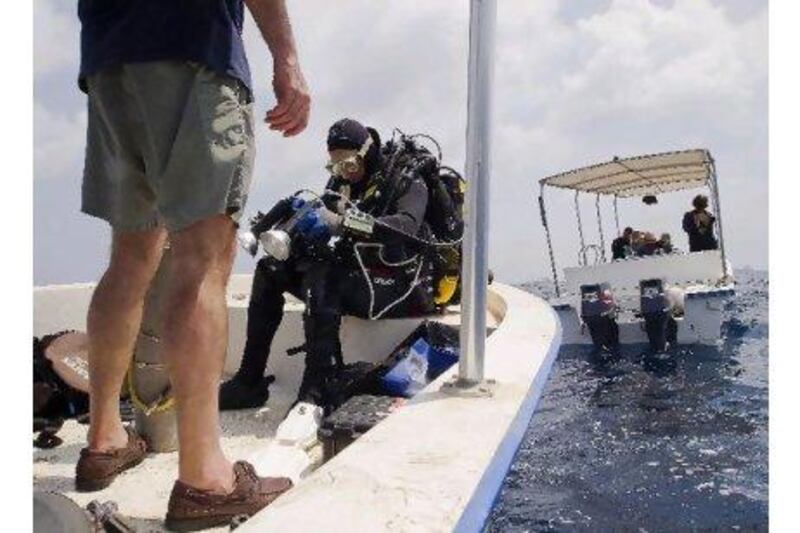 Bill Leeman checks his gear before entering the water.