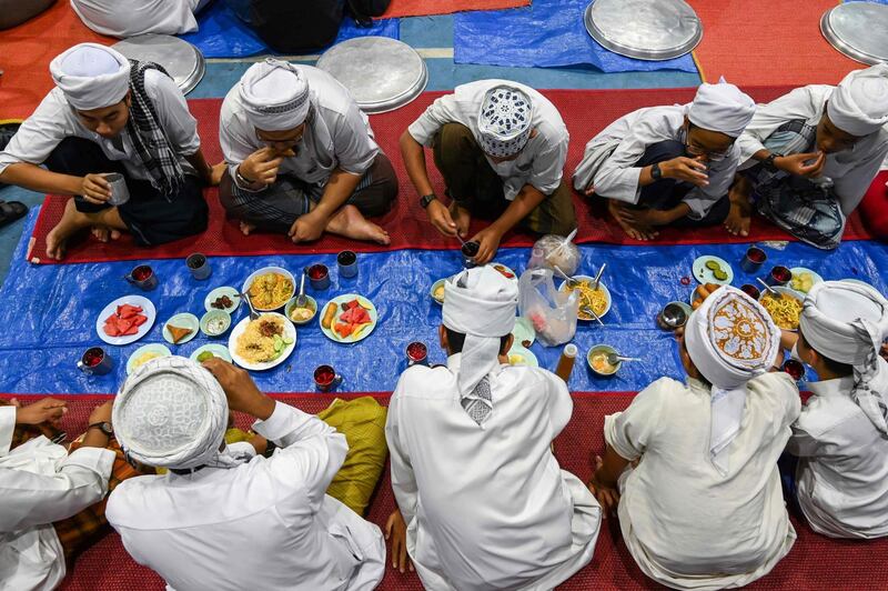 Thai Muslim youths breaking their fast during Ramadan in the compound of Haroon mosque in Bangkok. AFP