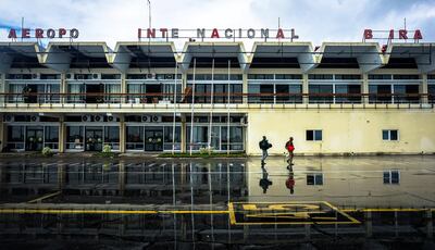 Arrivals walk in front of Beira International Airport’s damaged terminal in Beira, Mozambique, March 22, 2019. Jack Moore / The National