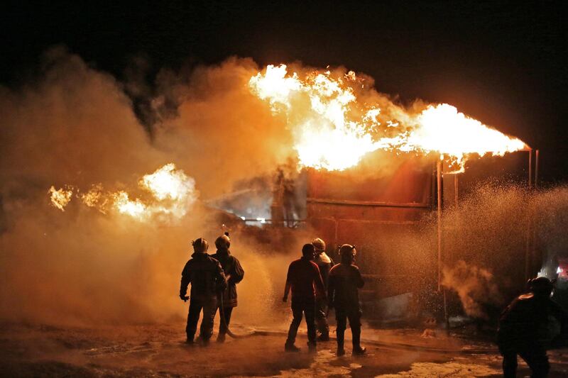 Members of the Syrian Civil Defence fight a fire which erupted after a bombardment of makeshift oil refining installations in the Tarhin area, near the Turkish-controlled city of Al Bab in the north of Aleppo province. AFP