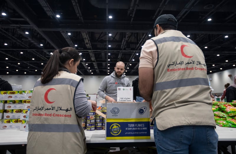 Volunteers pack food, blankets and other essential goods at the Dubai Exhibition Centre, at Expo City