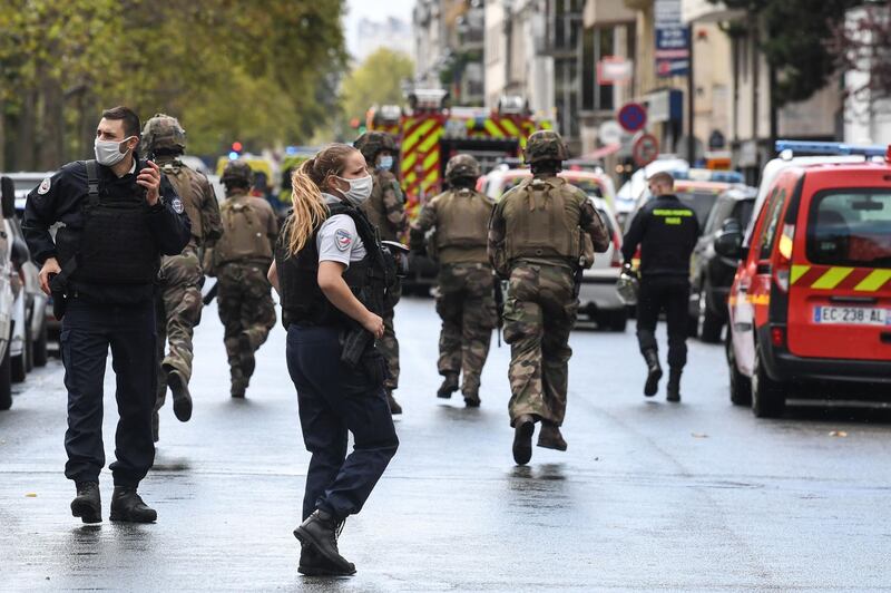 TOPSHOT - French army soldiers rush to the scene after several people were injured near the former offices of the French satirical magazine Charlie Hebdo following an alleged attack by a man wielding a knife in the capital Paris on September 25, 2020.  A man armed with a knife seriously wounded two people on September 25, 2020, in a suspected terror attack outside the former offices of French satirical weekly Charlie Hebdo in Paris, three weeks into the trial of men accused of being accomplices in the 2015 massacre of the newspaper's staff. Charlie Hebdo had angered many Muslims around the world by publishing cartoons of the Prophet Mohammed, and in a defiant gesture ahead of the trial this month, it reprinted the caricatures on its front cover. / AFP / Alain JOCARD
