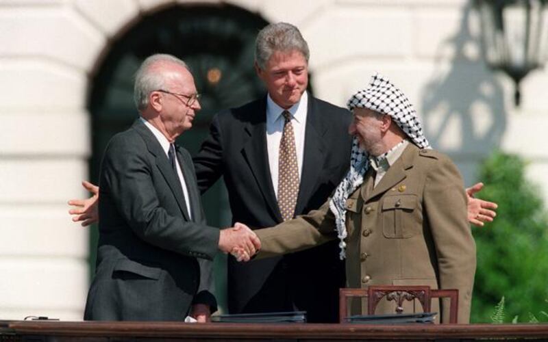 US President Bill Clinton (C) stands between PLO leader Yasser Arafat (R) and Israeli Prime Minister Yitzahk Rabin (L) as they shake hands 13 September 1993 at the White House in Washington DC. Rabin and Arafat shook hands for the first time after Israel and the PLO signed a historic agreement on Palestinian autonomy in the occupied territories. Rabin was assassinated reportedly by a Jewish extremist 04 November 1995 after attending a peace rally in Tel Aviv.
