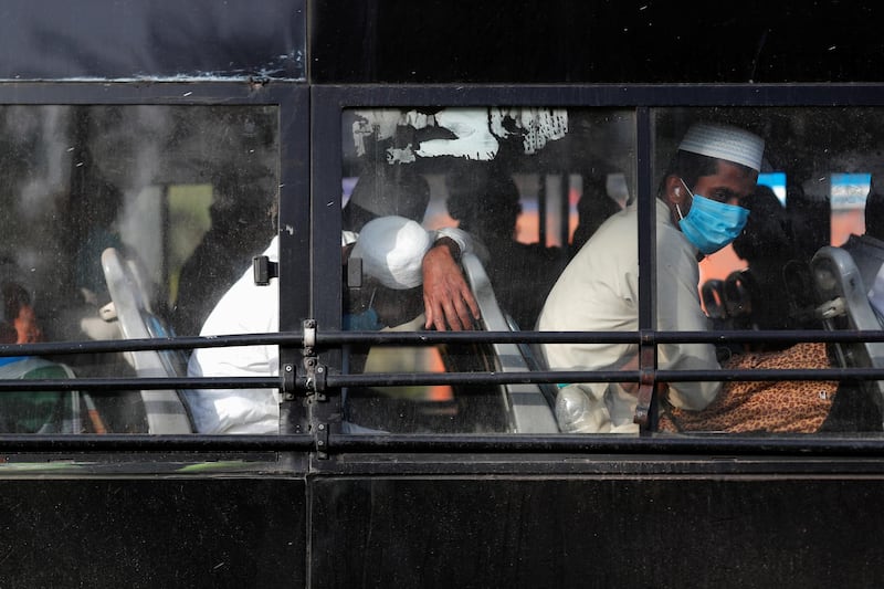 Men wearing protective masks sit inside a bus that will take them to a quarantine facility, amid concerns about the spread of coronavirus disease (COVID-19), in Nizamuddin area of New Delhi, India. REUTERS