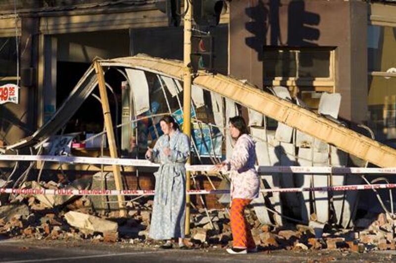 Residents stand outside a wrecked building after the earthquake in Christchurch on September 4.