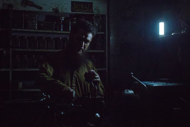 A machine operator uses an emergency light source at his workshop.