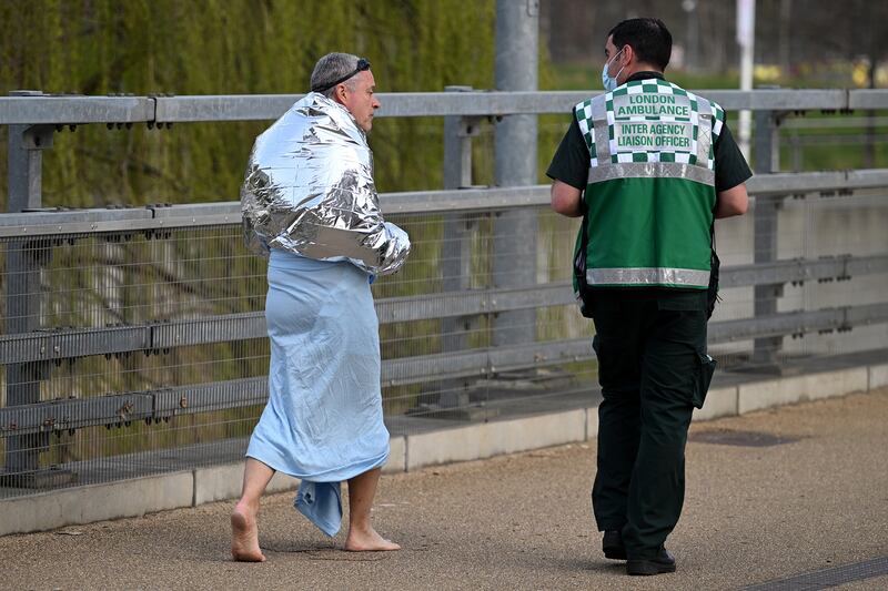 A member of the emergency services speaks to a man who was forced to leave the swimming pool suddenly. Getty Images