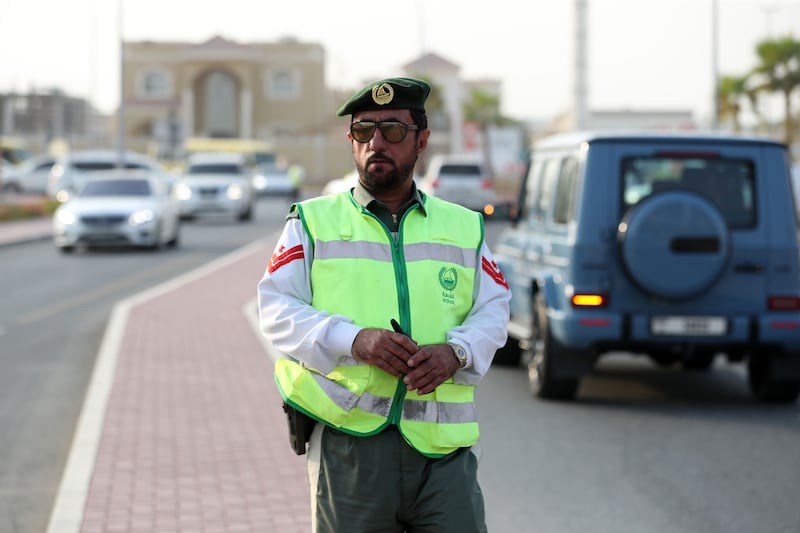 First Corporal Abdulrahman from Dubai Police directs traffic on the first day of term outside the School of Research Science in Dubai's Al Warqaa area. All photos: Chris Whiteoak / The National