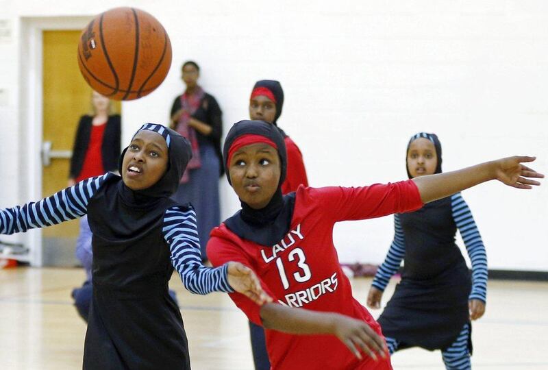 Amira Ali, right, and Rayan Ali, left, play basketball in their new uniforms designed specifically to adress Islamic dress beliefs. Jim Mone / AP