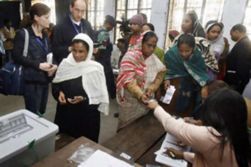 Graf Lambsdorff (background 2nd L), chief observer of the EU Election Observation Mission, and Naledi Lester (background L), press and public officer from the same organisation, watch Bangladeshi voters prepare to cast their votes at a polling station in Dhaka on December 29, 2008. Bangladesh went to the polls under tight security in the first elections here since 2001, with a pair of former leaders and bitter rivals vying to reclaim power in the impoverished nation. The vote will restore democracy to the south Asian country after two years of caretaker rule by an army-backed interim government, installed after a wave of political violence prevented the last scheduled elections.    AFP PHOTO/Deshakalyan CHOWDHURY *** Local Caption ***  982922-01-08.jpg