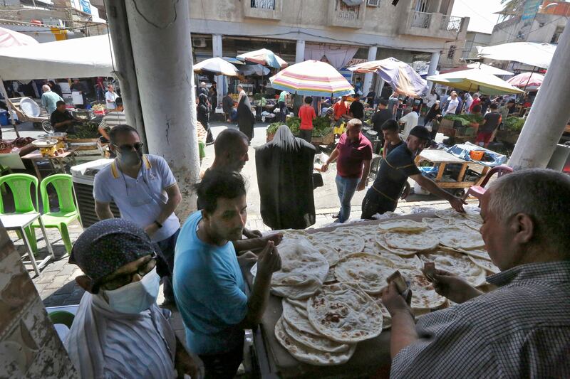 Iraqis buy traditional tannoor flat bread at a bakery in the capital Baghdad on September 10, 2021. The country improved its rankings on the Legatum global index over the past decade. AFP