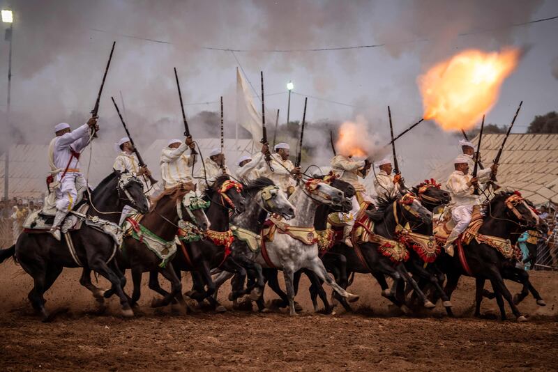 Moroccan horsemen fire their rifles during a traditional horse-riding performance at the Moussem culture and heritage festival in the capital Rabat. AFP