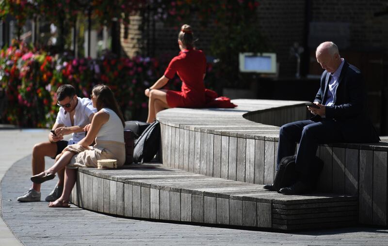 People sit in the sunshine in Kings Cross in London, Britain. EPA