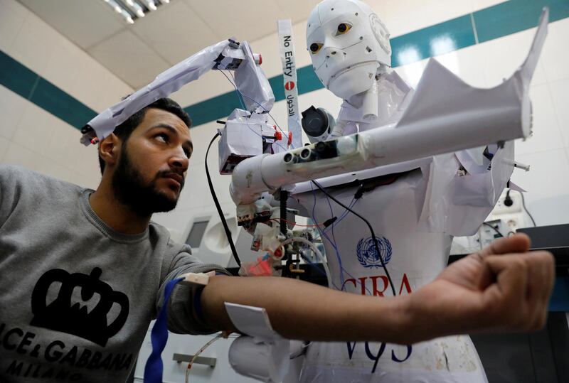 A volunteer is examined by Cira 3, a remote-controlled robot that runs tests on suspected Covid-19 patients to limit the human exposure to the virus, in Tanta, Egypt. Reuters