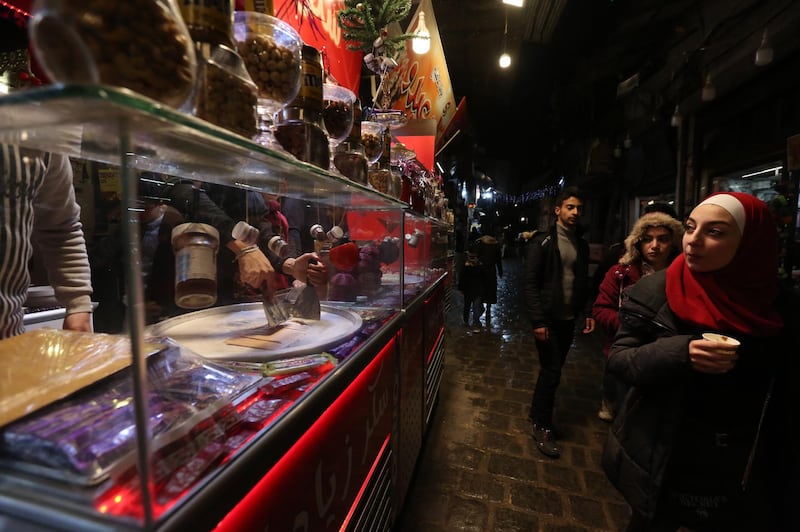 People shop in the Christian-populated Al-Qassaa neighborhood in Damascus, Syria. The area has been decorated as part of celebrations of Christmas and New Year.  EPA
