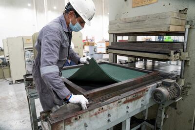 A worker removes a newly moulded rubber mat manufactured from recycled tyres at the EPSCO Global General Trading recycling company in Al Salmi, Kuwait. Reuters