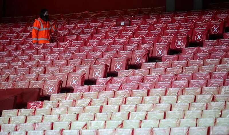 A steward walks among the empty seats in the stadium ahead of the English Premier League football match between Arsenal and Southampton at the Emirates Stadium in London on December 16, 2020.   - RESTRICTED TO EDITORIAL USE. No use with unauthorized audio, video, data, fixture lists, club/league logos or 'live' services. Online in-match use limited to 120 images. An additional 40 images may be used in extra time. No video emulation. Social media in-match use limited to 120 images. An additional 40 images may be used in extra time. No use in betting publications, games or single club/league/player publications.
 / AFP / POOL / PETER CZIBORRA / RESTRICTED TO EDITORIAL USE. No use with unauthorized audio, video, data, fixture lists, club/league logos or 'live' services. Online in-match use limited to 120 images. An additional 40 images may be used in extra time. No video emulation. Social media in-match use limited to 120 images. An additional 40 images may be used in extra time. No use in betting publications, games or single club/league/player publications.
