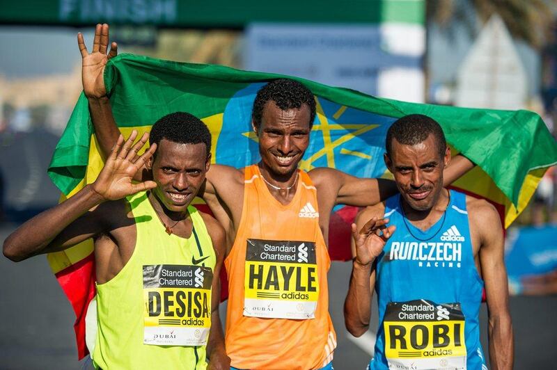 2015 Dubai Marathon winner Lemi Berhanu Hayle, centre, shown with second place finisher Lelisa Desisa, left, and third place finisher Deribe Robi, right, after the race on Friday. Stephen Hindley / AP