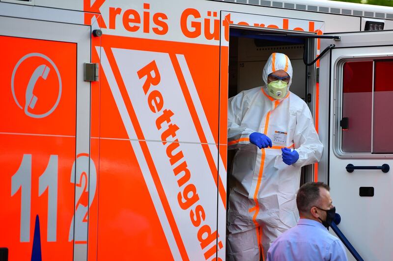 VERL, GERMANY - JUNE 20: A paramedic wearing full body protection stands inside an ambulance whilce local police forces secure an apartment complex used by the Toennies meat company to house foreign workers from eastern Europe during the coronavirus pandemic on June 20, 2020 in Verl, near Guetersloh, Germany. Authorities are considering a lockdown of the entire region following the confirmation of at least 800 Covid-19 infections among workers at the Toennies plant. A total of 7,000 people work at the facility and many of them have not yet been tested. Schools and child day care centers in the region have already been closed. (Photo by Alexander Koerner/Getty Images)