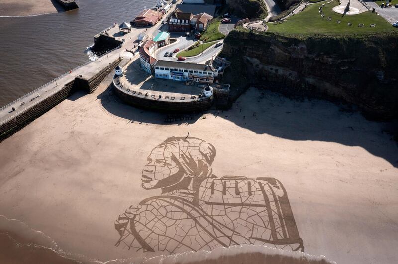 A giant sand portrait by WaterAid charity and artists Sand In Your Eye of Ansha, 12, from Frat, in Ethiopia, adorns Whitby beach in Whitby, England. Ansha has to walk for hours each day to collect dirty water from a river. Getty
