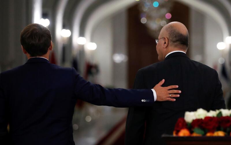 Iraqi President Barham Salih, right, and French President Emmanuel Macron leave after a joint press conference at the Salam Palace.  AP