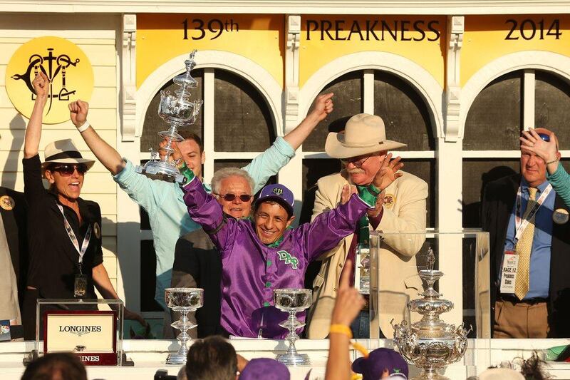 Jockey Victor Espinoza celebrates with owner Steve Coburn and trainer Art Sherman after winning the 139th Preakness Stakes atop California Chrome on Saturday. Matthew Stockman / Getty Images / AFP / May 17, 2014