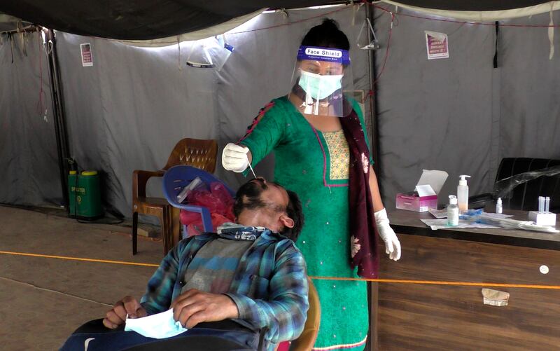 A Nepalese health worker tests a man for Covid-19 in Nepalgunj.