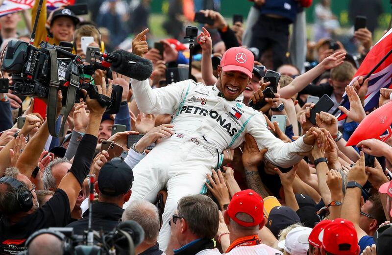 epa07716848 British Formula One driver Lewis Hamilton of Mercedes AMG GP crowd surfs as he celebrates winning the Formula One Grand Prix of Great Britain at the Silverstone circuit, in Northamptonshire, Britain, 14 July 2019.  EPA/GEOFF CADDICK