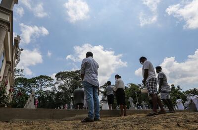 epa08374724 Relatives pay their respects at the grave of an Easter Sunday 2019 suicide bomb attack victim, at the St. Sebastian's church, in Katuwapitiya,  Sri Lanka, 21 April 2020. This year the 21 April marks the first anniversary of a terrorist attack that saw three churches and three luxury hotels targeted in Colombo, in series of coordinated suicide bombings. The bombings killed more than 250 people.  EPA/CHAMILA KARUNARATHNE